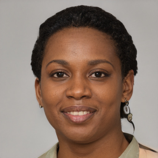 Joyful black young-adult female with short  black hair and brown eyes