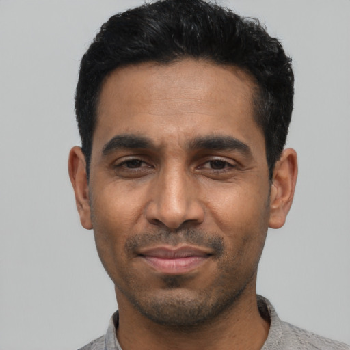 Joyful latino young-adult male with short  black hair and brown eyes