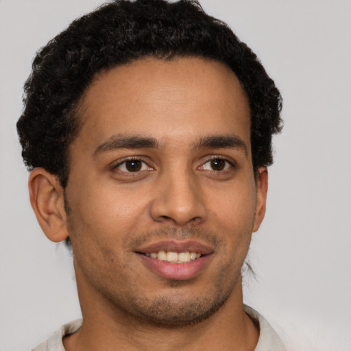 Joyful latino young-adult male with short  brown hair and brown eyes