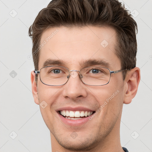 Joyful white young-adult male with short  brown hair and grey eyes