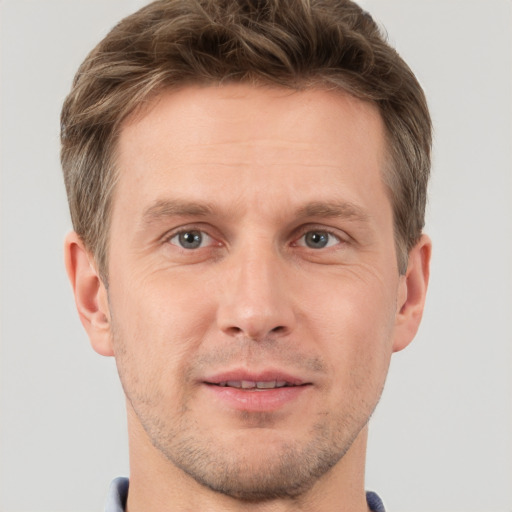 Joyful white adult male with short  brown hair and grey eyes