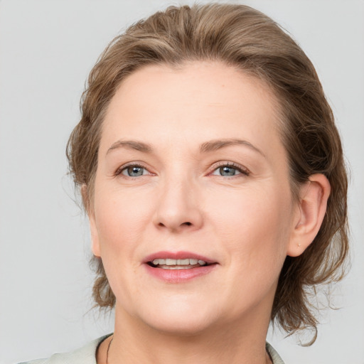 Joyful white adult female with medium  brown hair and grey eyes