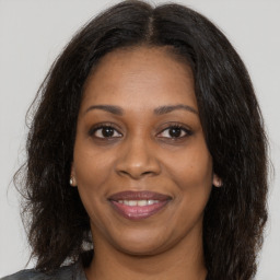 Joyful black adult female with long  brown hair and brown eyes