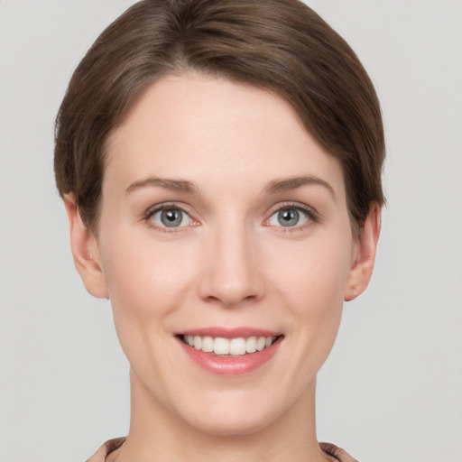 Joyful white young-adult female with short  brown hair and grey eyes