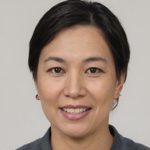 Joyful asian adult female with medium  brown hair and brown eyes