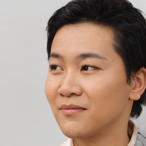 Joyful asian young-adult male with medium  black hair and brown eyes