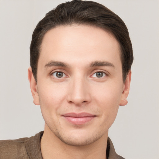 Joyful white young-adult male with short  brown hair and grey eyes