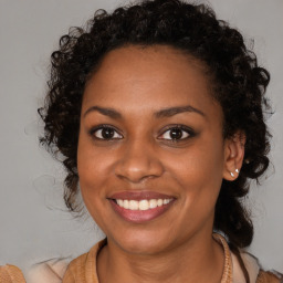 Joyful black young-adult female with long  brown hair and brown eyes