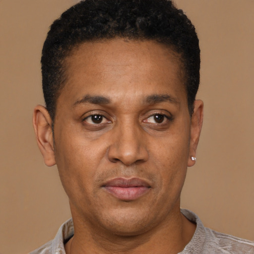 Joyful latino young-adult male with short  brown hair and brown eyes