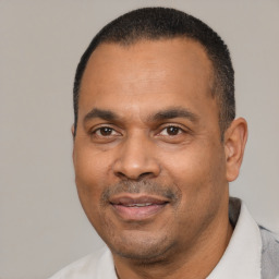 Joyful latino adult male with short  black hair and brown eyes