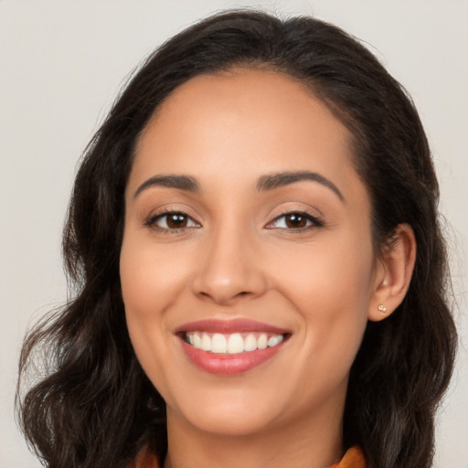 Joyful latino young-adult female with long  brown hair and brown eyes