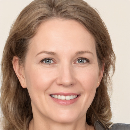 Joyful white adult female with medium  brown hair and grey eyes