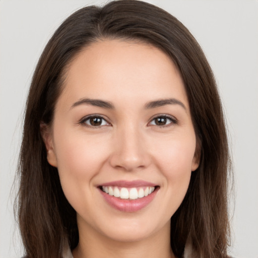 Joyful white young-adult female with long  brown hair and brown eyes