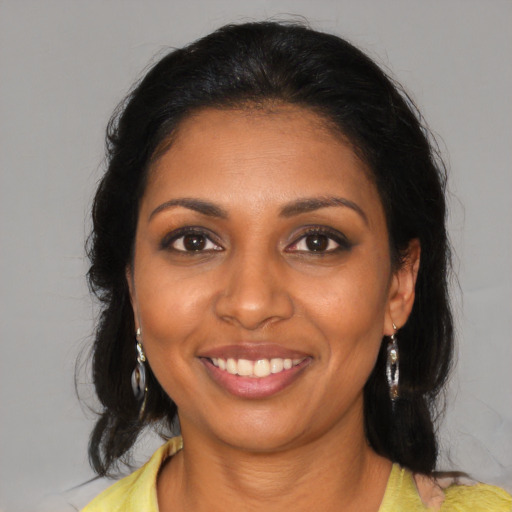 Joyful black young-adult female with medium  brown hair and brown eyes