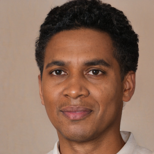Joyful black young-adult male with short  black hair and brown eyes