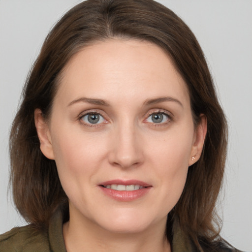 Joyful white young-adult female with medium  brown hair and grey eyes