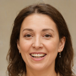 Joyful white adult female with long  brown hair and brown eyes