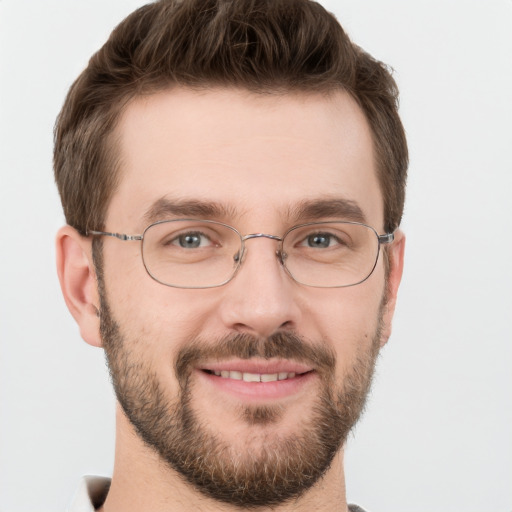 Joyful white young-adult male with short  brown hair and grey eyes