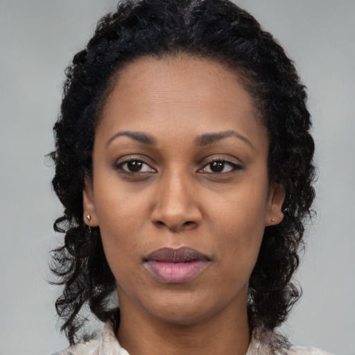 Joyful black young-adult female with medium  brown hair and brown eyes