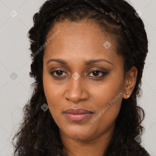 Joyful black adult female with long  brown hair and brown eyes