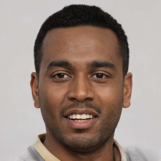 Joyful black young-adult male with short  black hair and brown eyes
