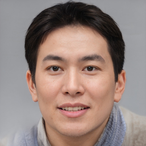 Joyful asian young-adult male with short  brown hair and brown eyes