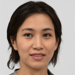 Joyful asian young-adult female with medium  brown hair and brown eyes