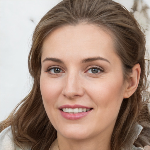 Joyful white young-adult female with long  brown hair and grey eyes