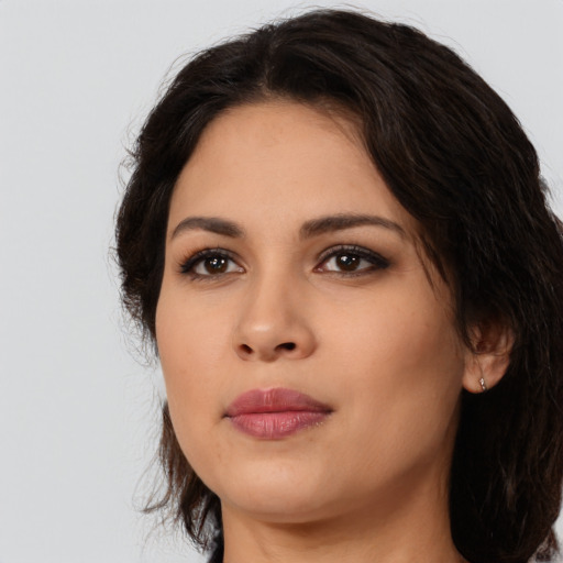 Joyful latino young-adult female with medium  brown hair and brown eyes