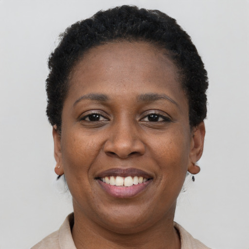 Joyful black young-adult female with short  black hair and brown eyes