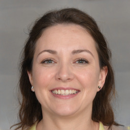 Joyful white adult female with medium  brown hair and blue eyes