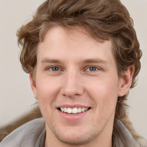 Joyful white young-adult male with medium  brown hair and grey eyes