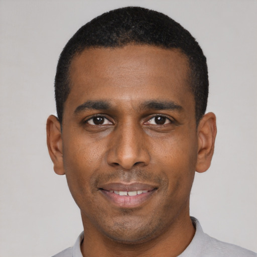 Joyful black young-adult male with short  black hair and brown eyes