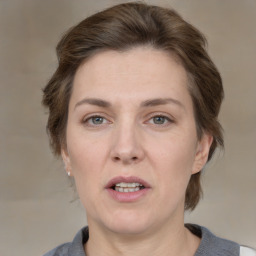 Joyful white adult female with medium  brown hair and grey eyes