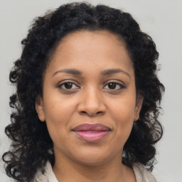 Joyful black adult female with medium  brown hair and brown eyes