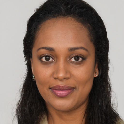 Joyful black young-adult female with long  brown hair and brown eyes