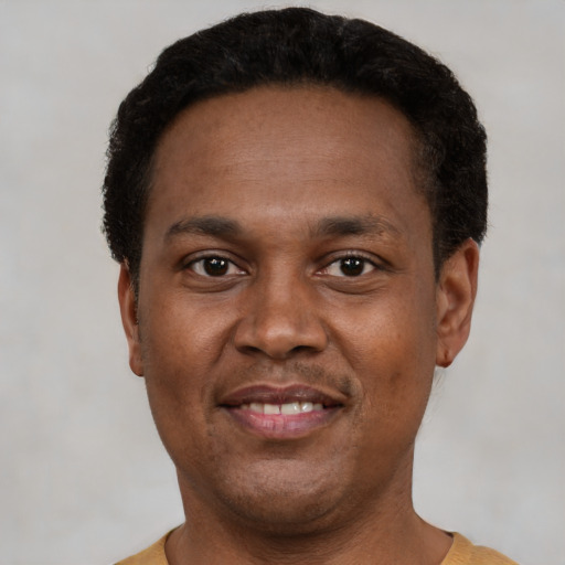 Joyful black young-adult male with short  black hair and brown eyes
