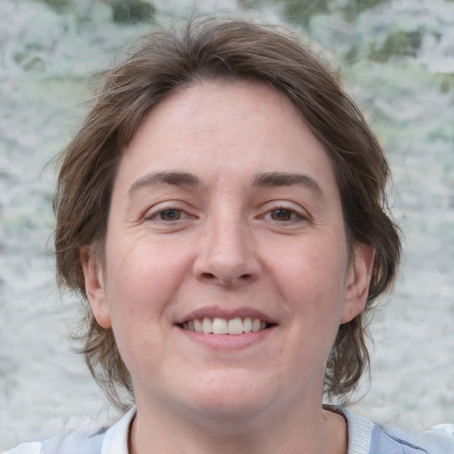 Joyful white adult female with medium  brown hair and grey eyes