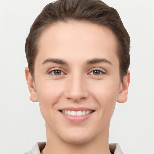 Joyful white young-adult female with short  brown hair and grey eyes