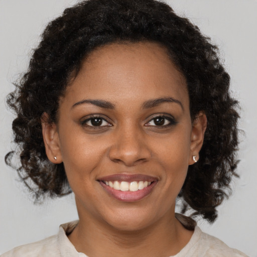 Joyful black young-adult female with medium  brown hair and brown eyes