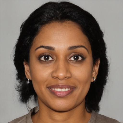 Joyful black young-adult female with medium  black hair and brown eyes