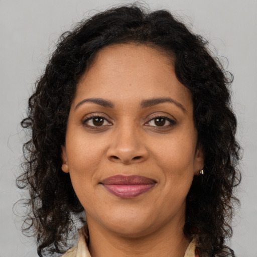 Joyful black adult female with long  brown hair and brown eyes