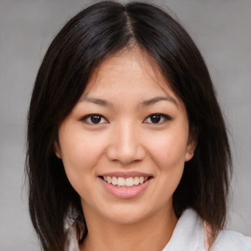 Joyful asian young-adult female with medium  brown hair and brown eyes