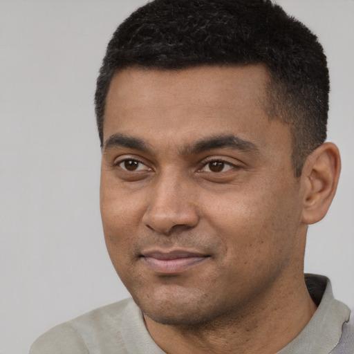 Joyful latino young-adult male with short  black hair and brown eyes