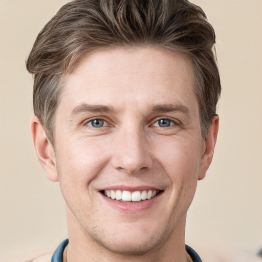 Joyful white young-adult male with short  brown hair and grey eyes