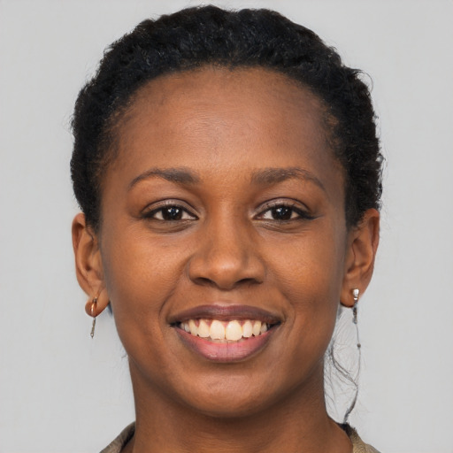 Joyful black young-adult female with short  brown hair and brown eyes