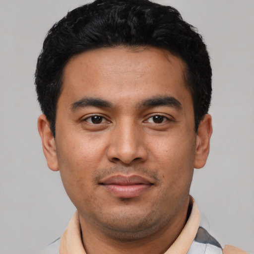 Joyful latino young-adult male with short  black hair and brown eyes