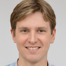 Joyful white young-adult male with short  brown hair and grey eyes