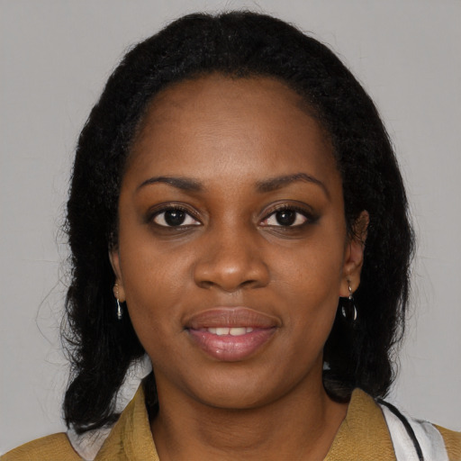 Joyful black young-adult female with long  black hair and brown eyes