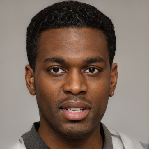 Joyful black young-adult male with short  black hair and brown eyes